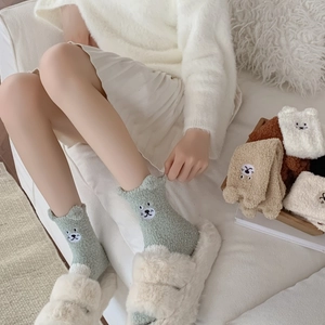 Close-up of thick coral fleece socks with 3D animal embroidery and wavy cuff detail