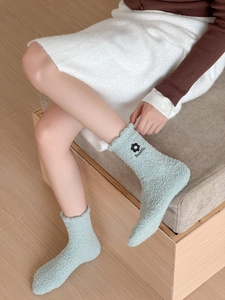 Close-up of soft mint green coral fleece socks featuring black flower and Beautiful embroidery