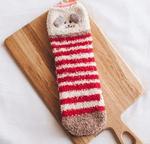 Détails de la texture des chaussettes en polaire corail à rayures rouges avec oreilles 3D