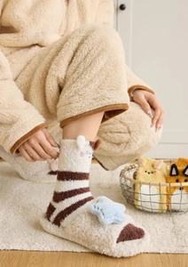 Détail de chaussettes d'hiver en polaire corail avec motif alpaga et pantoufles en peluche