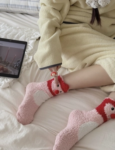 Close-up of pink coral fleece socks featuring cute 3D cartoon character and fluffy texture