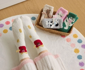 Close-up of thick coral fleece socks with 3D cartoon animal patterns and soft texture
