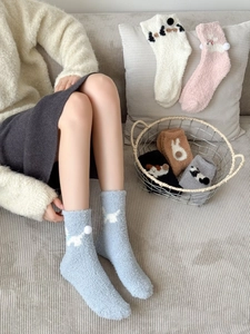 Detailed view of thick coral fleece winter socks with soft plush balls and animal motifs