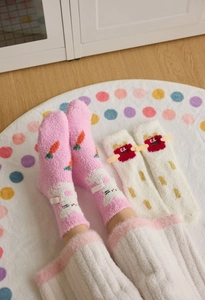 Close-up of thick coral fleece winter socks with cartoon rabbit and carrot embroidery