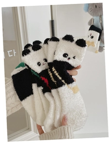 Gros plan de la broderie panda 3D sur des chaussettes douces en polaire corail