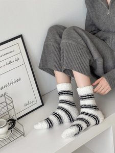 Detail of coral fleece striped socks on model feet showing soft plush texture and comfort