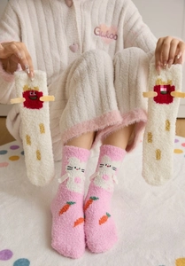 Detail of coral fleece socks featuring pink rabbit and white French fries cartoon patterns