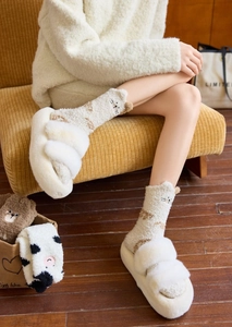 Detail of coral fleece cat socks and plush slippers for warm winter home wear