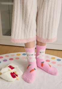 Close-up of pink coral fleece socks featuring cute 3D hand details and cat patterns