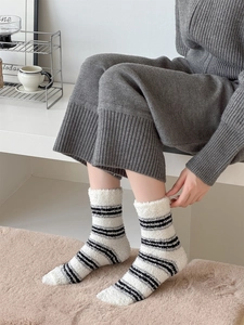 Close-up of soft black and white striped coral fleece socks for warm winter home wear