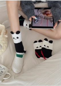 Détail de chaussettes en polaire corail avec oreilles de panda 3D et peluche