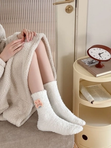 Close-up of white coral fleece socks featuring cute pink rabbit embroidery for winter
