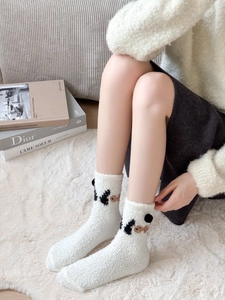 Fluffy white coral fleece socks with cute 3D bear ears on cozy carpet background