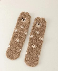 Close-up of thick coral fleece socks featuring cute brown 3D bear head and paw prints