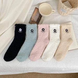 Detailed view of five plush coral fleece socks in pastel colors with floral embroidery