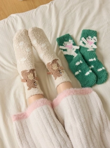 Close-up of fluffy coral fleece socks featuring cute bear and cat animal decorations