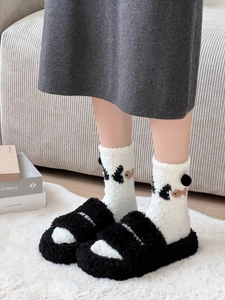 Close-up of fluffy coral fleece panda socks with 3D pompoms and cozy plush slippers