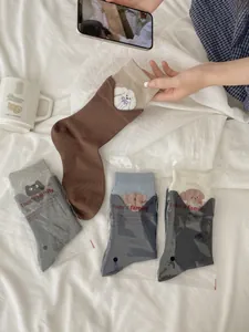 Detail of cute cat and dog embroidery on colorful cotton mid-calf socks for women