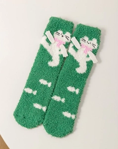 Detail of plush green coral fleece sock featuring cute cat motif and small fish patterns