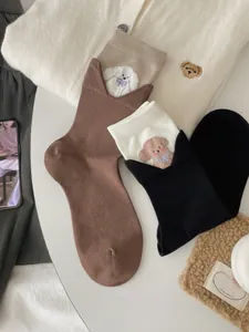 Close-up of V-shaped ribbed cuffs with cute rabbit and dog embroidery on cotton socks
