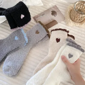 Detailed view of soft coral fleece socks featuring cute embroidered hearts in various colors