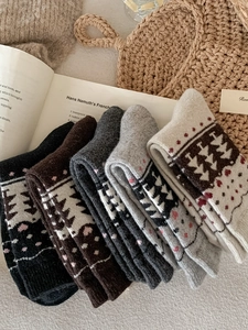 Detail of five pairs of thick Fair Isle wool socks in Nordic patterns and warm earthy tones