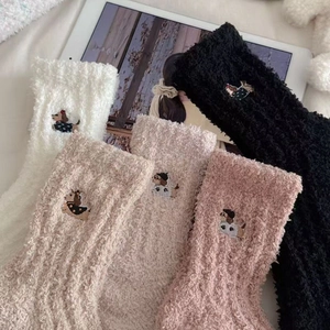 Detail of coral fleece winter socks featuring cute dog embroidery and soft texture