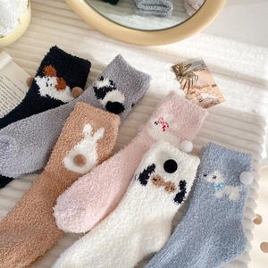 Close-up of thick coral fleece socks in multiple colors with cute animal jacquard patterns