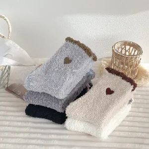 Detail view of plush coral fleece heart embroidery socks in assorted warm colors