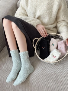 Detail of dachshund embroidery on thick coral fleece socks with various pastel colors