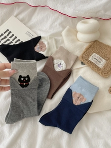 Detail view of cotton socks with cute 3D embroidered animal patterns and colorful cuffs