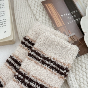 Close-up of thick striped coral fleece socks showing soft plush texture and cozy knit details