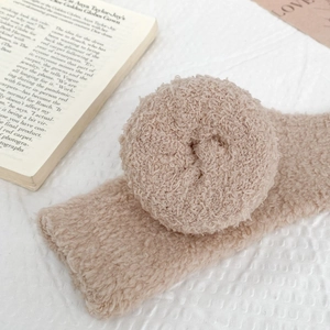 Close-up of soft beige coral fleece socks with warm curly lamb wool texture and cozy feel