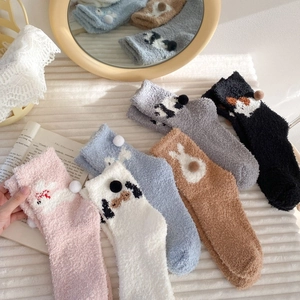 Close-up of fluffy coral fleece winter socks in multiple colors with cute animal patterns