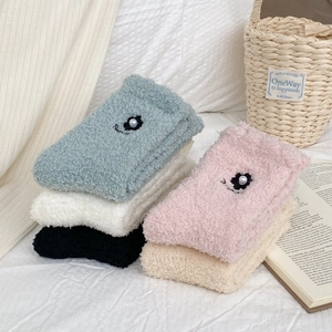 Macro detail of coral fleece socks in pastel colors with 3D flower and pearl decor