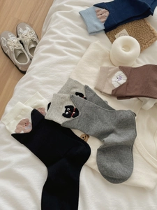 Detailed close-up of cartoon animal embroidery on colorful cotton crew socks