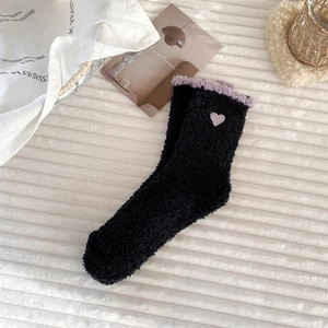 Detail of soft black coral fleece socks with purple heart embroidery and plush trim