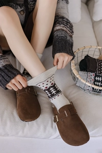 Detail of wool knit socks with Fair Isle pattern worn with brown suede buckle clogs
