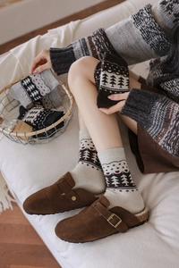 Detail of wool blend Fair Isle socks with nordic patterns and warm fleece-lined slippers