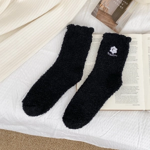 Close-up of soft coral fleece socks featuring embroidered flower and 'Beautiful' text