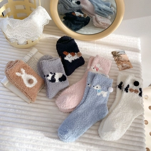 Close-up of thick coral fleece winter socks with cute 3D animal ears and pom poms