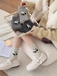 Dettaglio di calze di lana spesse con ricamo panda 3D in grigio tenue e bianco crema