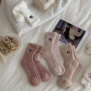 Detail of coral fleece winter socks with cute animal embroidery and soft velvet texture