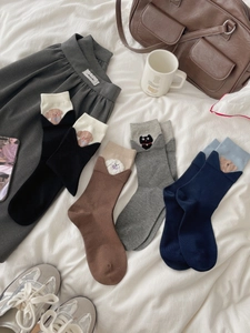 Flat lay of cotton crew socks with cute cartoon animal embroidery and fold-over cuffs
