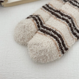 Detailed macro view of the soft coral fleece fabric on these striped thermal home socks