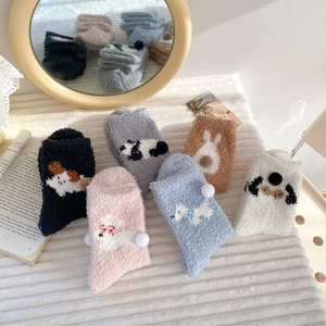 Detail of six pairs of thick coral fleece socks with cute 3D animal patterns and pom-poms