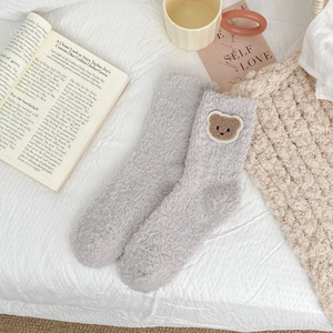 Close-up of soft grey coral fleece socks with cute brown bear embroidery detail