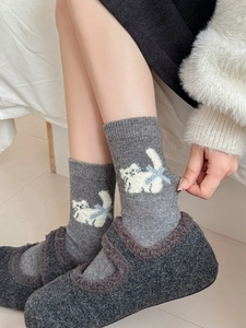 Détail de chaussettes en laine avec broderie de chat et texture en tricot épais