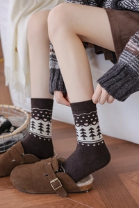 Close-up of thick Fair Isle wool socks with pine tree motifs and retro brown knit texture