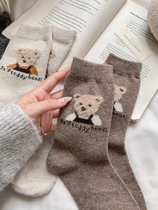 Gros plan de chaussettes en laine d'hiver épaisses avec motif d'ours et texture moelleuse